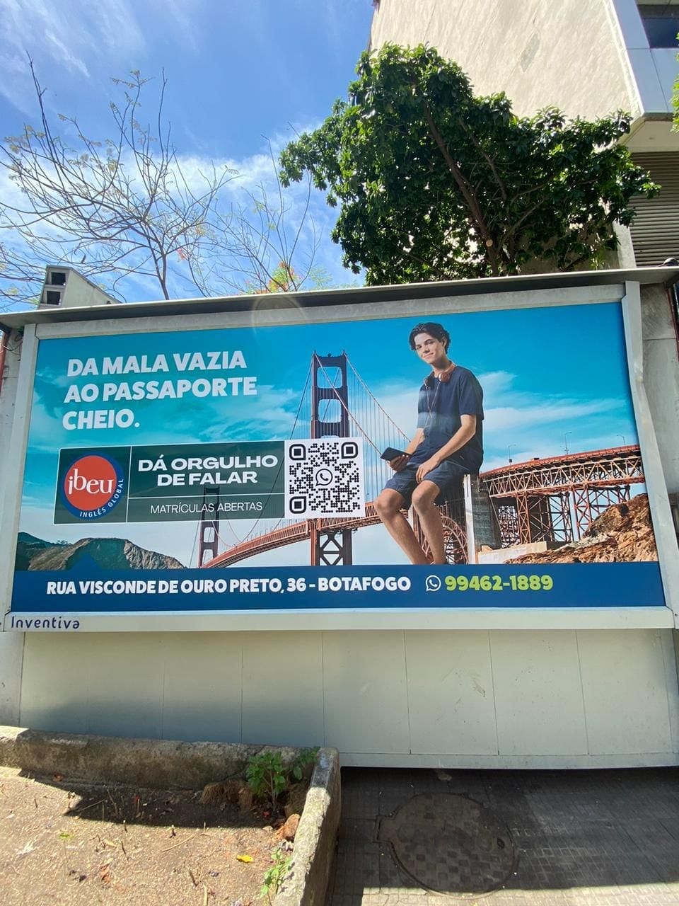 Painel de rua do Ibeu com a frase Da mala vazia ao passaporte cheio