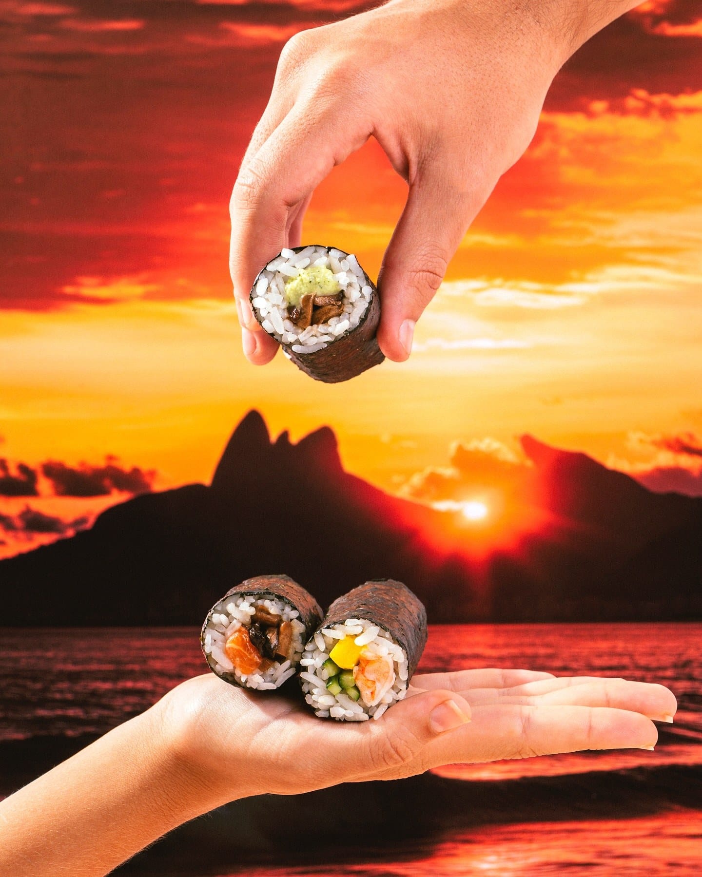 Hand rolls nas mãos diante do pôr do sol atrás do Morro Dois Irmãos, no Rio