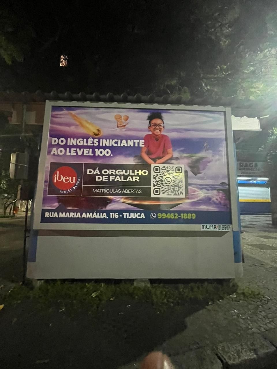 Painel iluminado do Ibeu à noite, com a frase Do inglês iniciante ao level 100
