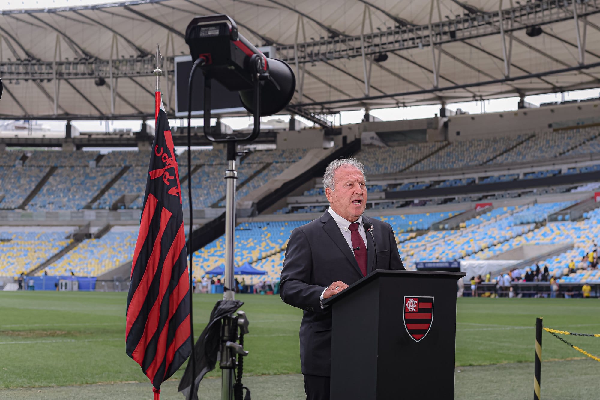 Plano aberto do discurso de Zico no gramado, com a luz da gravação ao lado