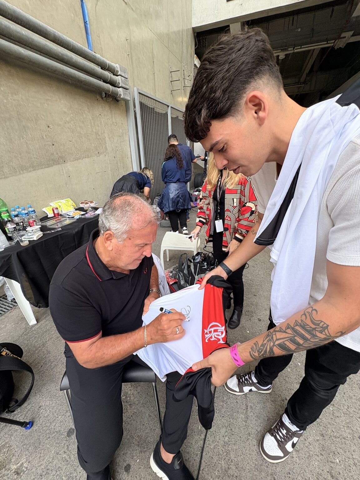 Zico autografa uma camisa do Flamengo nos bastidores