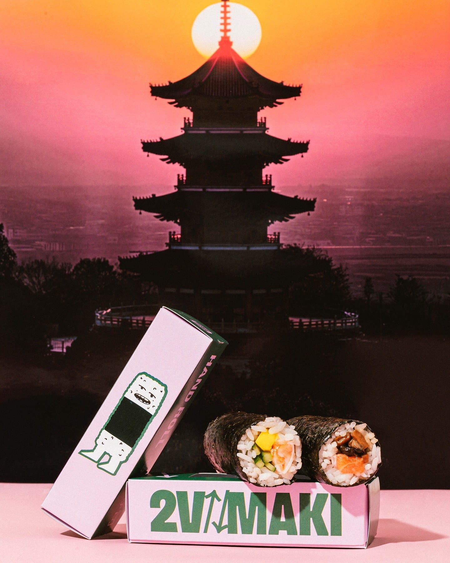 Embalagem 2V Maki e hand rolls diante da silhueta de um pagode ao pôr do sol