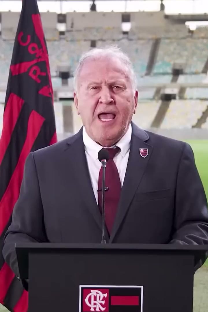 Zico discursa no púlpito, no gramado do Maracanã, com a bandeira da campanha Nação na ONU ao fundo