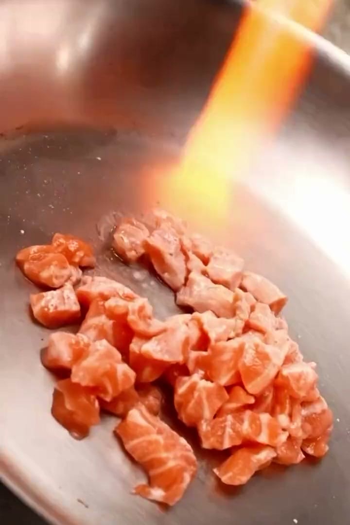 Still do onigiri da 2V sobre três embalagens triangulares, diante de uma rua noturna de Tóquio